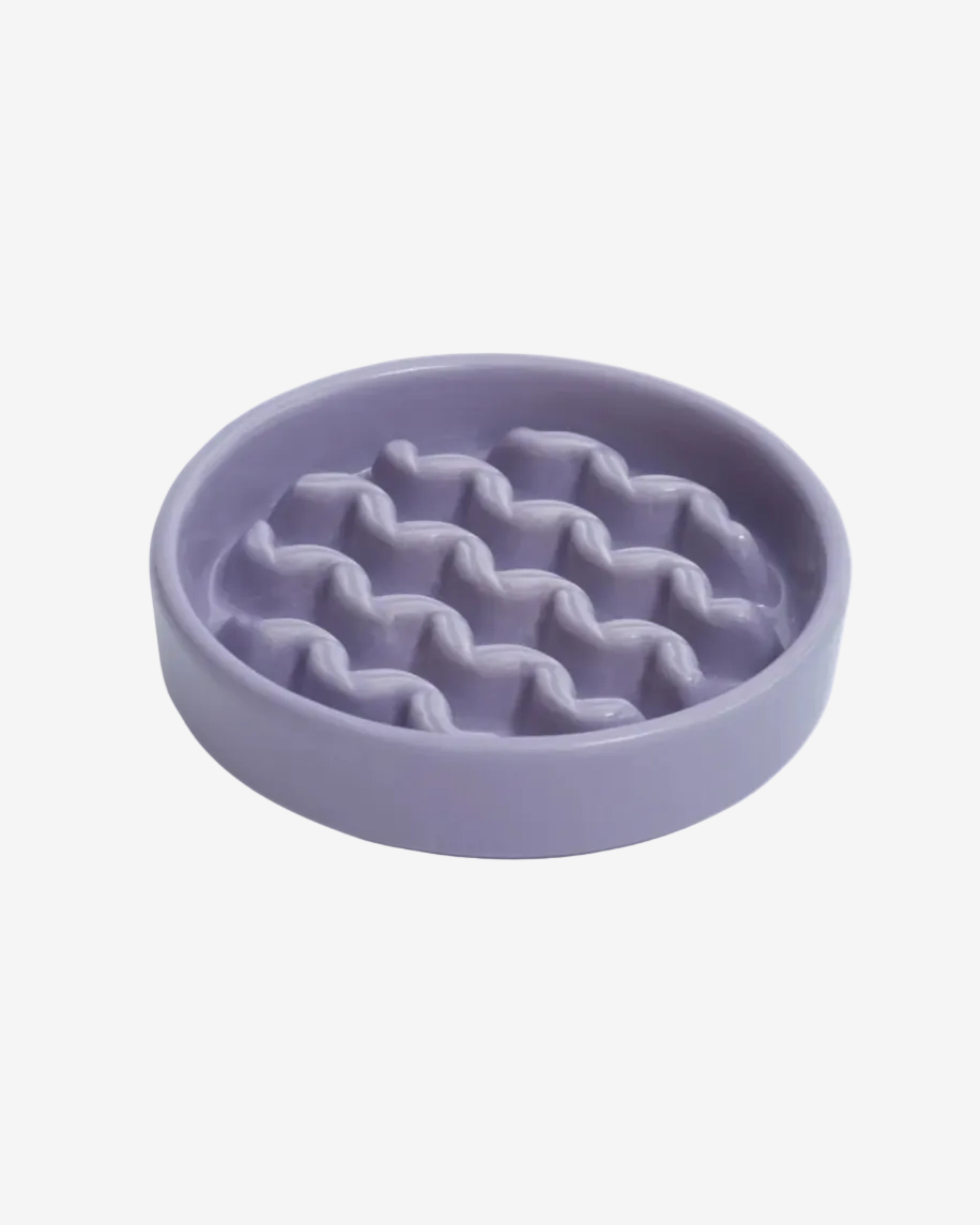 Purple macroni-shaped ceramic slow feeder dog bowl on a white background