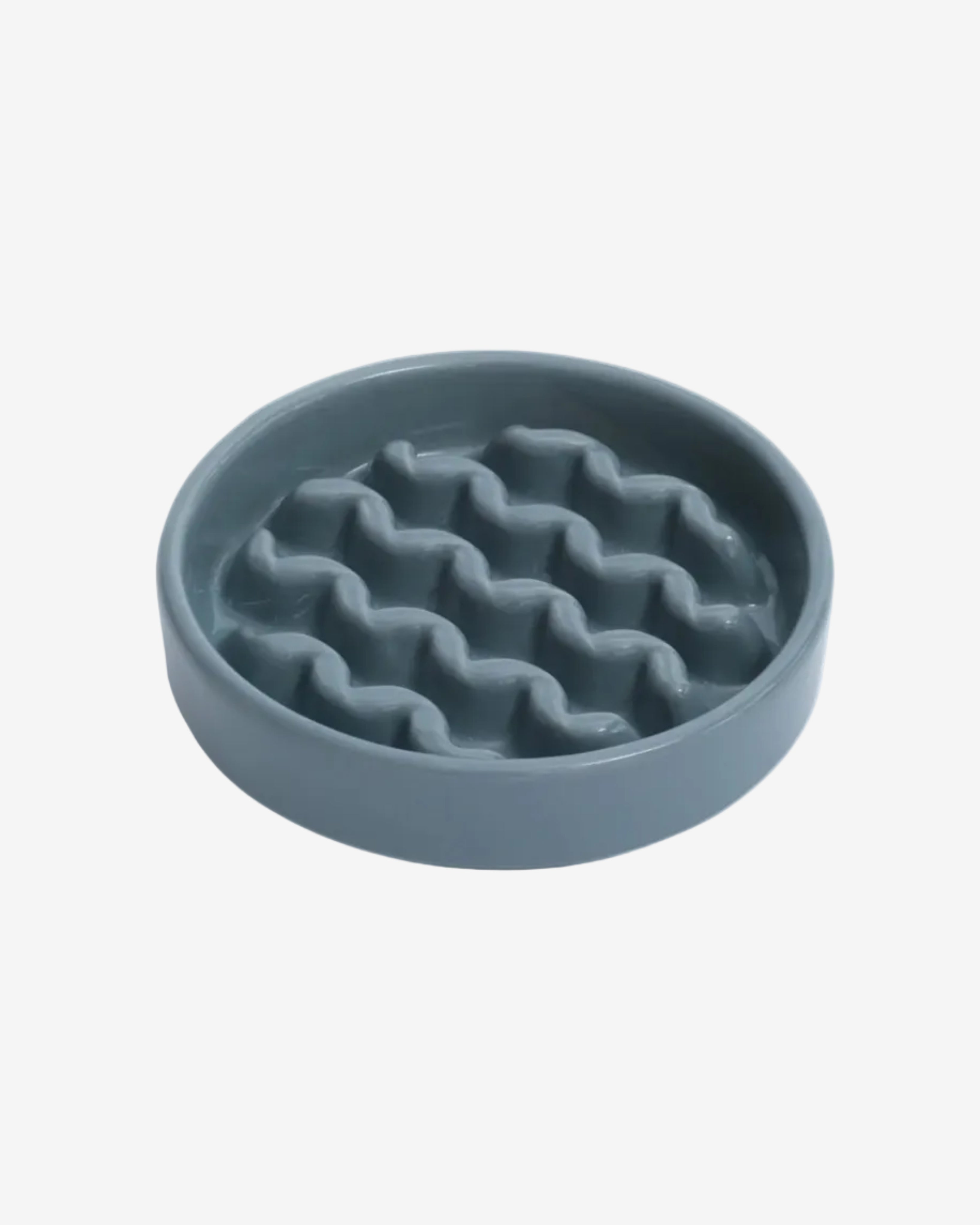 Blue macroni-shaped slow feeder bowl on a white background