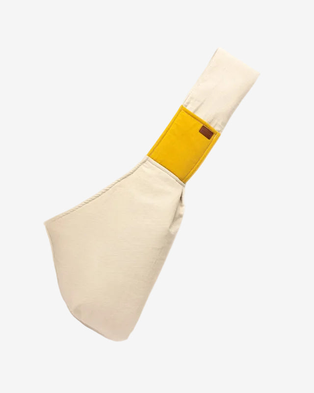 A beige pet travel sling carrier bag with a yellow strap, displayed against a white background.