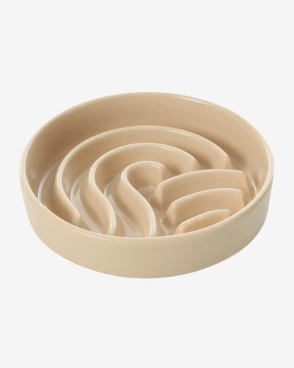 Beige wave-shaped slow feeder dog bowl on a white background