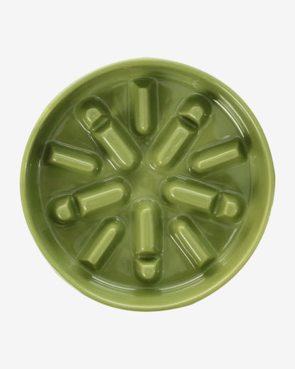 Green spark-shaped ceramic slow feeder bowl on a white background